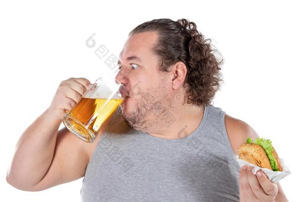有趣的肥的男人吃汉堡包和喝<strong>饮料</strong>乙醇<strong>饮料</strong>向whiteiron白铁