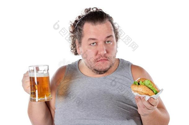 有趣的肥的男人<strong>吃汉堡</strong>包和喝饮料乙醇饮料向whiteiron白铁