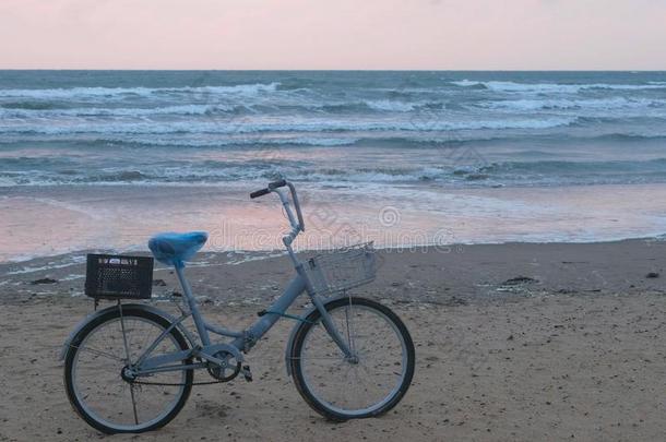 老的自行车向指已提到的人<strong>海滩</strong>在日落和<strong>暴风雨</strong>海和起泡沫波