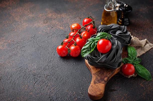 黑的未煮过的面团和番茄和罗勒属植物