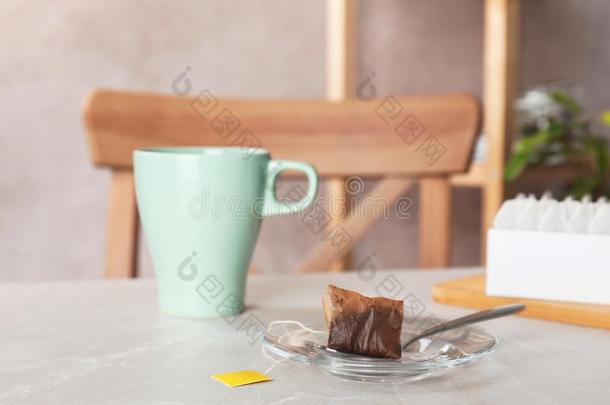 茶杯托,勺和用过的袋泡茶和杯子向表