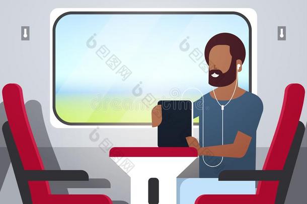 男人火车乘客收听的听觉的书和耳机非洲的