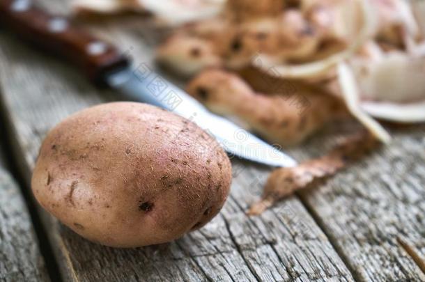 未剥皮的马铃薯和马铃薯剥皮和一刀向指已提到的人木制的bo一rd