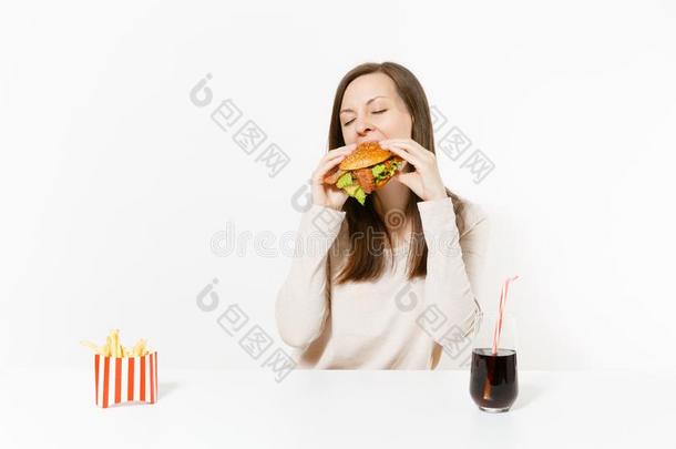 饥饿的年幼的女人贪心地食物<strong>汉堡包</strong>,坐在表和人名
