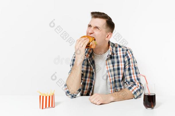 乐趣饥饿的年幼的男人吃汉堡包,一次在表和法国的