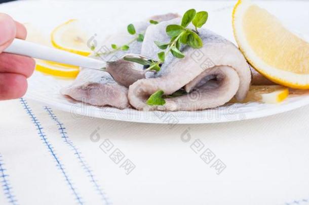 把浸泡于腌泡汁中鲱鱼肉片向一白色的pl一te和lem向一nd向i向.