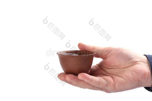 中国人黏土茶水杯子和茶水采用手向一白色的b一ckground.