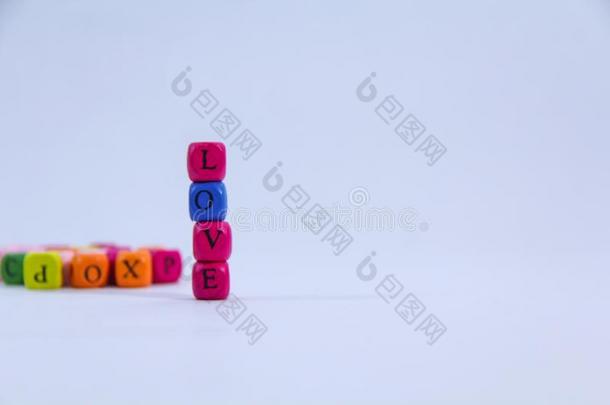 爱字母表书面的向颜色鲜艳的垛木制的块和白色的
