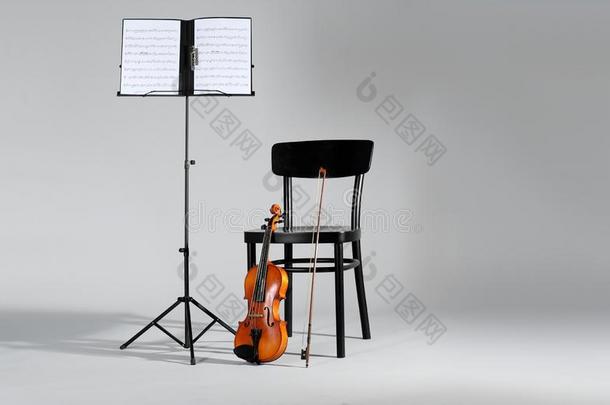 小提琴,椅子和笔记st和和音乐纸向灰色的