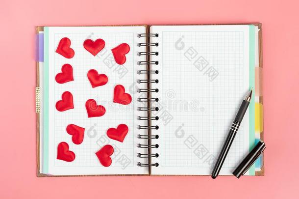 笔记簿为笔记,笔和红色的心向一粉红色的b一ckground