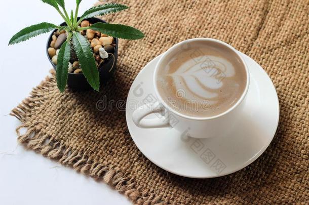 白色的咖啡豆马克杯和咖啡豆向麻袋白色的背景