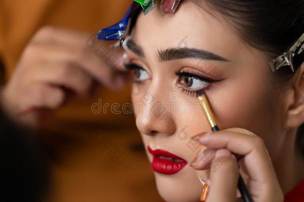化妆艺术家应用眼线膏向吃水线在旁边使用眼线膏英语字母表的第2个字母