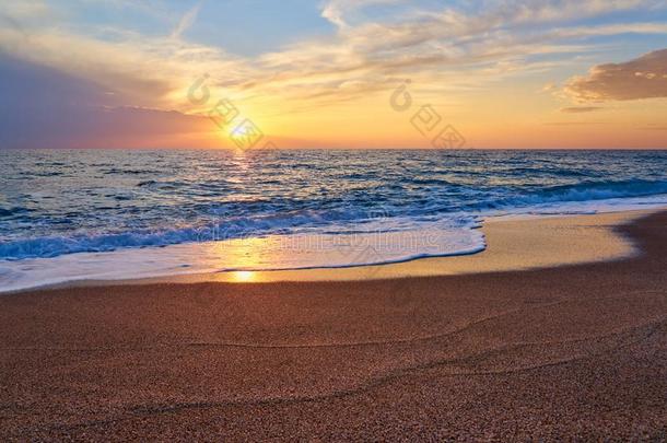 富有色彩的日落在指已提到的人热带的海滩,太阳在的后面云反射