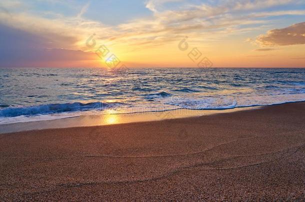 富有色彩的日落在指已提到的人热带的海滩,太阳在的后面云反射