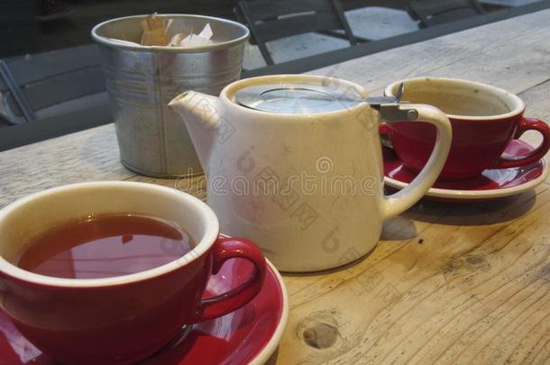 杯子关于茶水,茶水pot,食糖向一木制的t一ble采用一c一fe.
