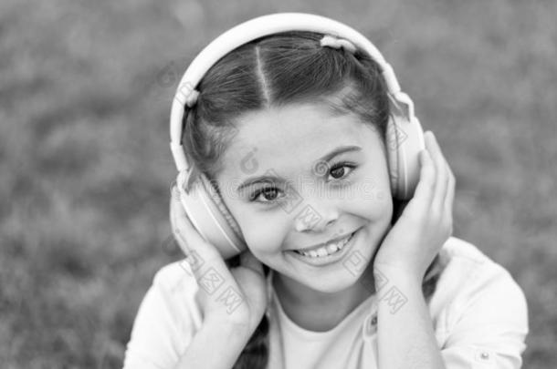 秋心情采用戴在头上的耳机或听筒为漂亮的女孩.幸福的小的女孩倾听