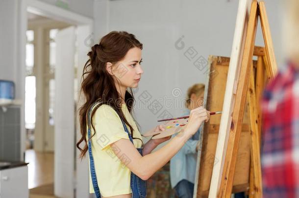 女人和画架绘画在艺术学校工作室
