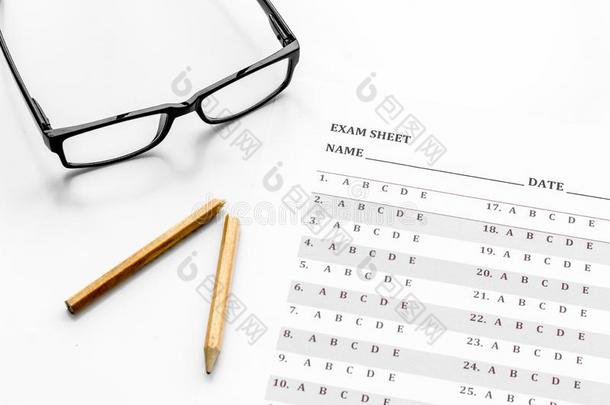 拿指已提到的人考试.考试纸在近处眼镜和铅笔向白色的后面