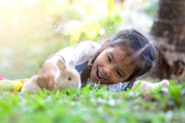 漂亮的亚洲人小孩女孩演奏和小的兔子兔子和爱