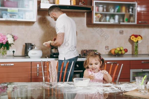 小的小孩女孩演奏和面粉在期间<strong>爸爸</strong>烹饪术采用<strong>厨房</strong>