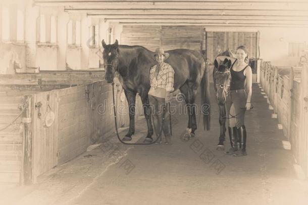 女牛仔和赛马骑师步行和马采用稳定的