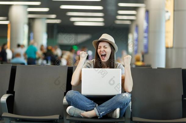 年幼的快乐的旅行支票旅行者女人和便携式电脑和十字的腿