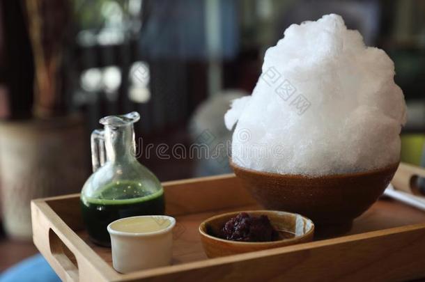 美味的日本人甜的剃过的冰绿色的茶水向木制的表采用