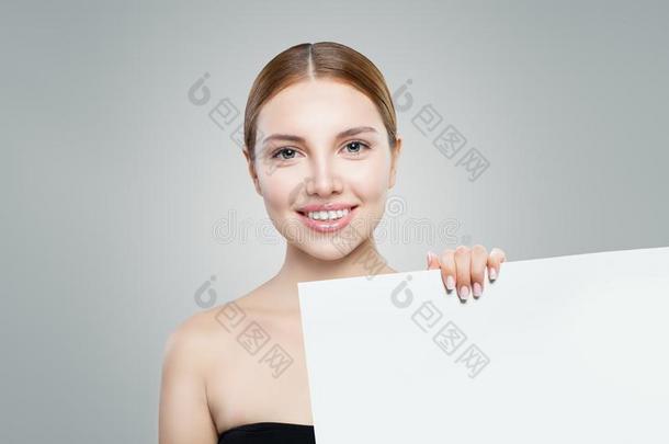 完美的模型女孩展映白色的空的纸广告牌为广告