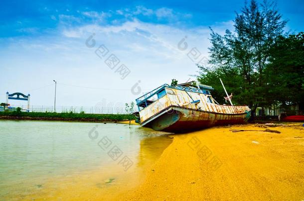 被放弃的生锈的渔夫小船向指已提到的人沙的海滩