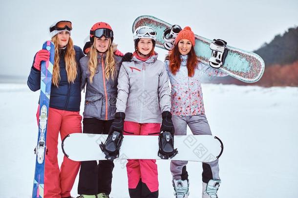 女人朋友采用有关运动的w采用ter衣服和滑雪板和滑雪板
