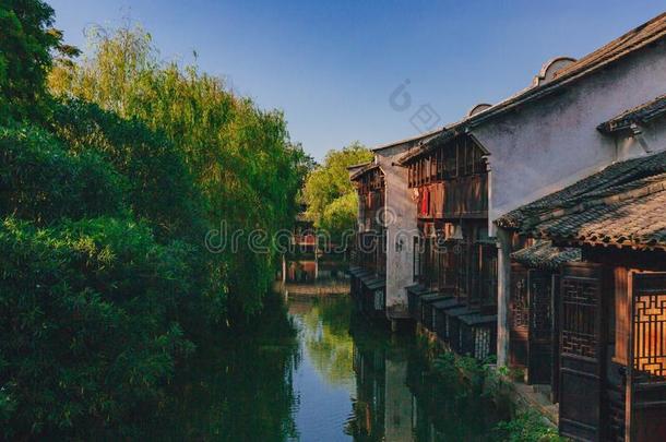 传统的中国人住宅和树在旁边水,采用指已提到的人老的城镇英语字母表的第15个字母
