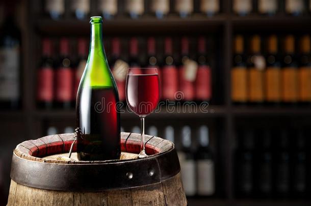 葡萄酒瓶子和玻璃关于红色的葡萄酒向木制的桶.葡萄酒架子一