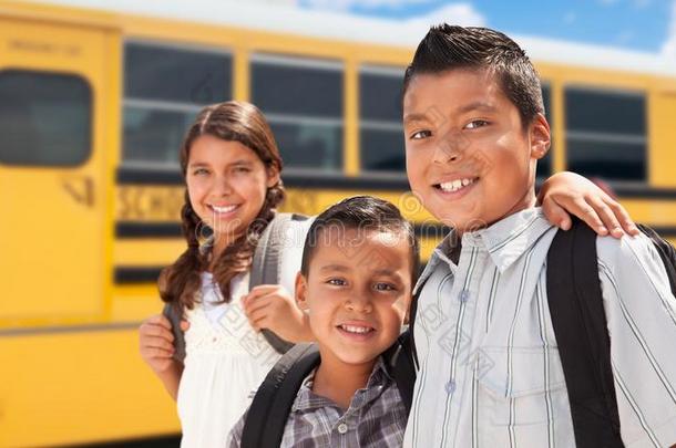 年幼的西班牙的男孩和女孩步行在近处学校公共汽车