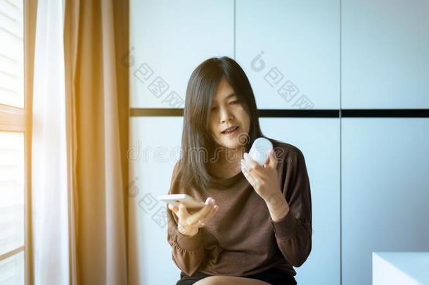 亚洲人女人使用可移动的电话搜索的信息和阅读