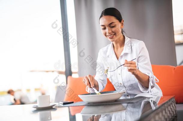 腰在上面关于微笑的女人有样子的在食物向她餐叉