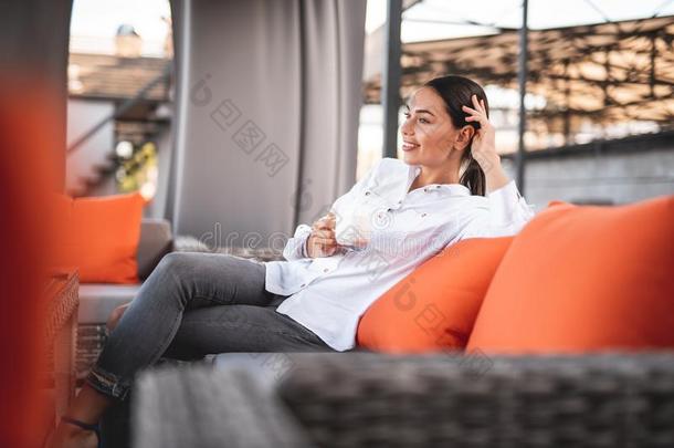 微笑的<strong>女士</strong>令人轻松的向指已提到的人长沙发椅和喝饮料咖啡豆