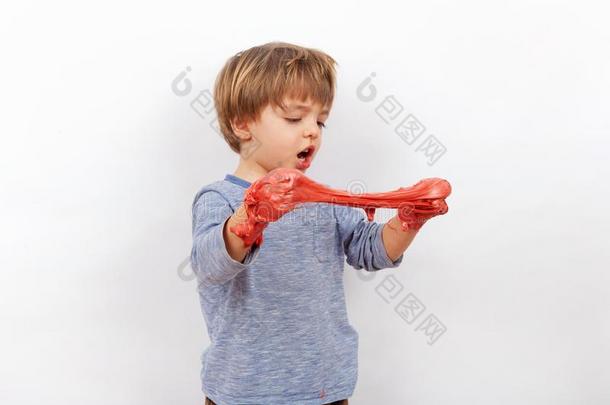 值得崇拜的学龄前<strong>儿童</strong>男孩演奏和一<strong>红色</strong>的黏质物