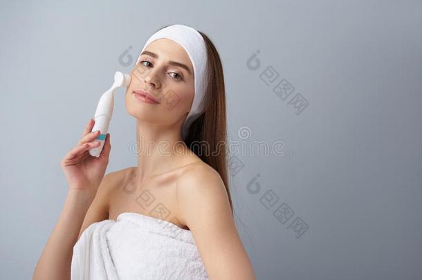 美丽的年幼的女士使用<strong>毛孔</strong>清洁刷子后的沐浴