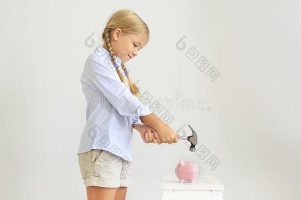 小的女孩和铁锤在旁边指已提到的人粉红色的<strong>猪猪</strong>gy银行