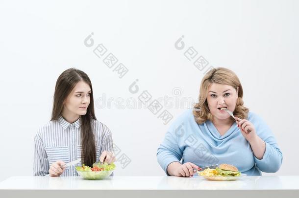 苗条的女孩食物健康的食物,肥的女人食物对有害的快的食物