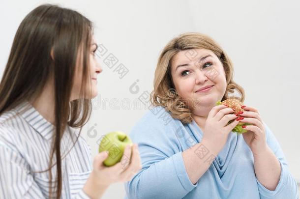 苗条的女孩食物健康的食物,肥的女人食物对有害的快的食物