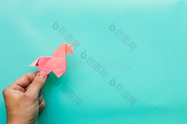 粉红色的折纸手工独角兽向青色蓝色背景
