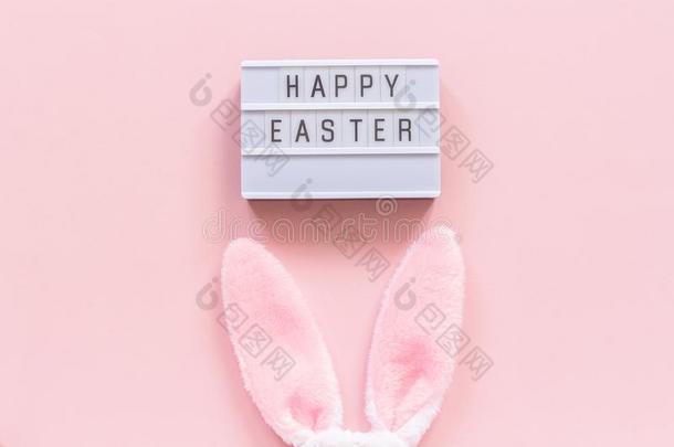 灯箱文本幸福的复活节和兔子耳向粉红色的纸后台