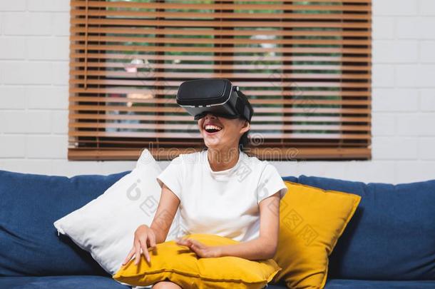 亚洲人女人穿着VirtualReality虚拟现实戴在头上的耳机或听筒眼镜和比赛事实上的现实Slovenia斯洛文尼亚