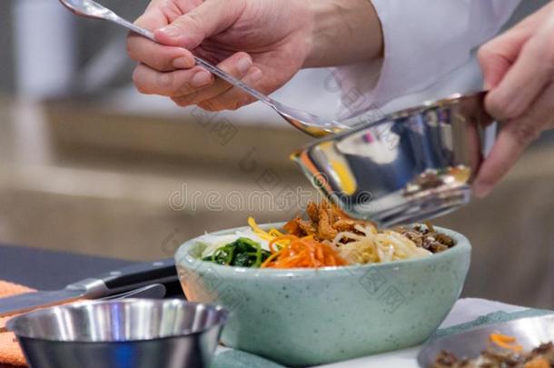 韩式拌饭,传统的朝鲜人烹饪韩式拌饭,厨师准备的kick-off开球
