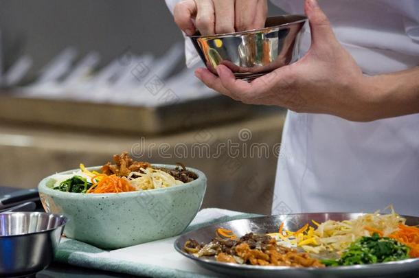 韩式拌饭,传统的朝鲜人烹饪韩式拌饭,厨师准备的kick-off开球