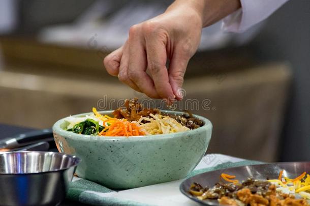 韩式拌饭,传统的朝鲜人烹饪韩式拌饭,厨师准备的kick-off开球