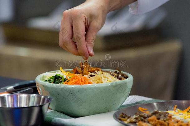 韩式拌饭,传统的朝鲜人烹饪韩式拌饭,厨师准备的kick-off开球