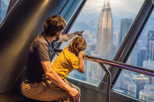 爸爸和儿子是有样子的在吉隆坡吉隆坡城市风光照片.全景的竞争
