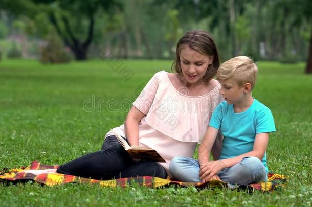 母亲和儿子做家庭作业同时采用公园,小孩教育,